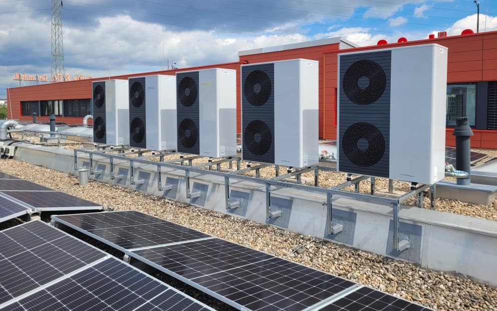 Dach eines Gebäudes mit einer Reihe von externen Wärmepumpeneinheiten.