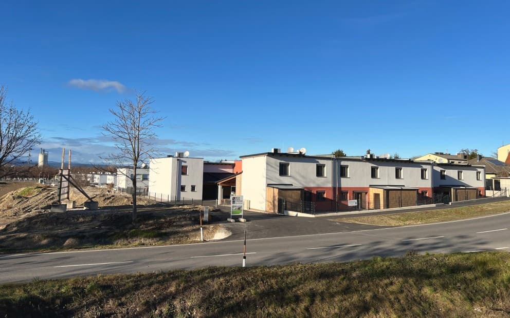 Haus am Straßenrand in einem Dorf mit blauem Himmel.
