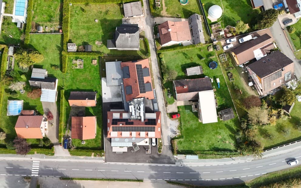 Luftaufnahme von Häusern und Gärten eines Dorfes.