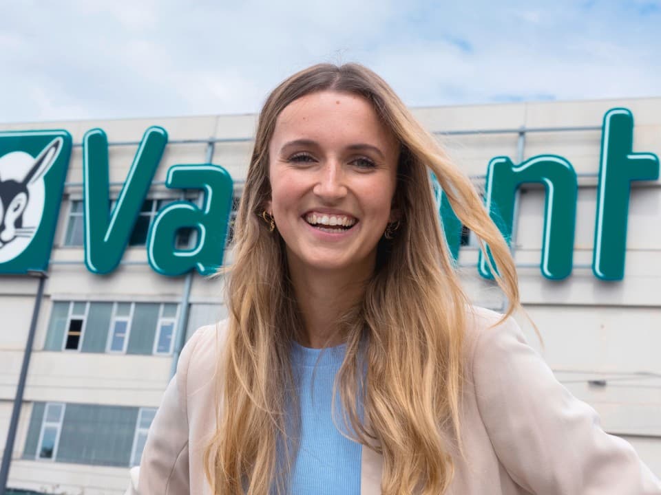 Frau, die lächelt vor einem Vaillant Gebäude
